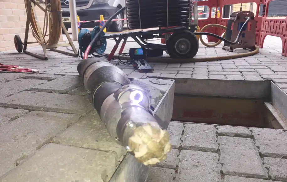 Robotic cutting equipment being prepared for insertion into an underground drain to remove obstructions.