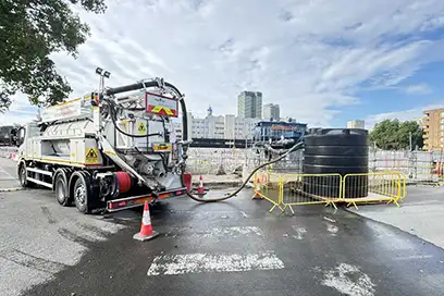 Pinpoint Drainage Services vacuum tanker carrying out specialist liquid waste transfer and site drainage operations on a major construction project.
